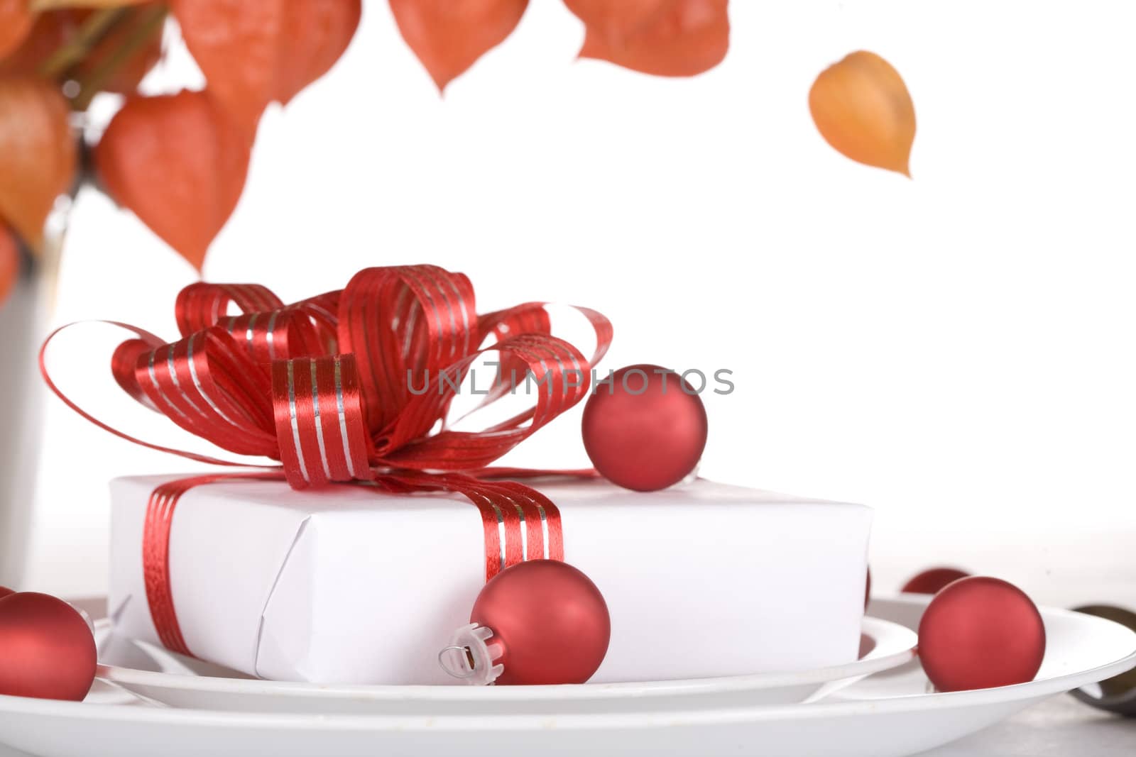 White present with red ribbons on a dinner plate, christmas theme