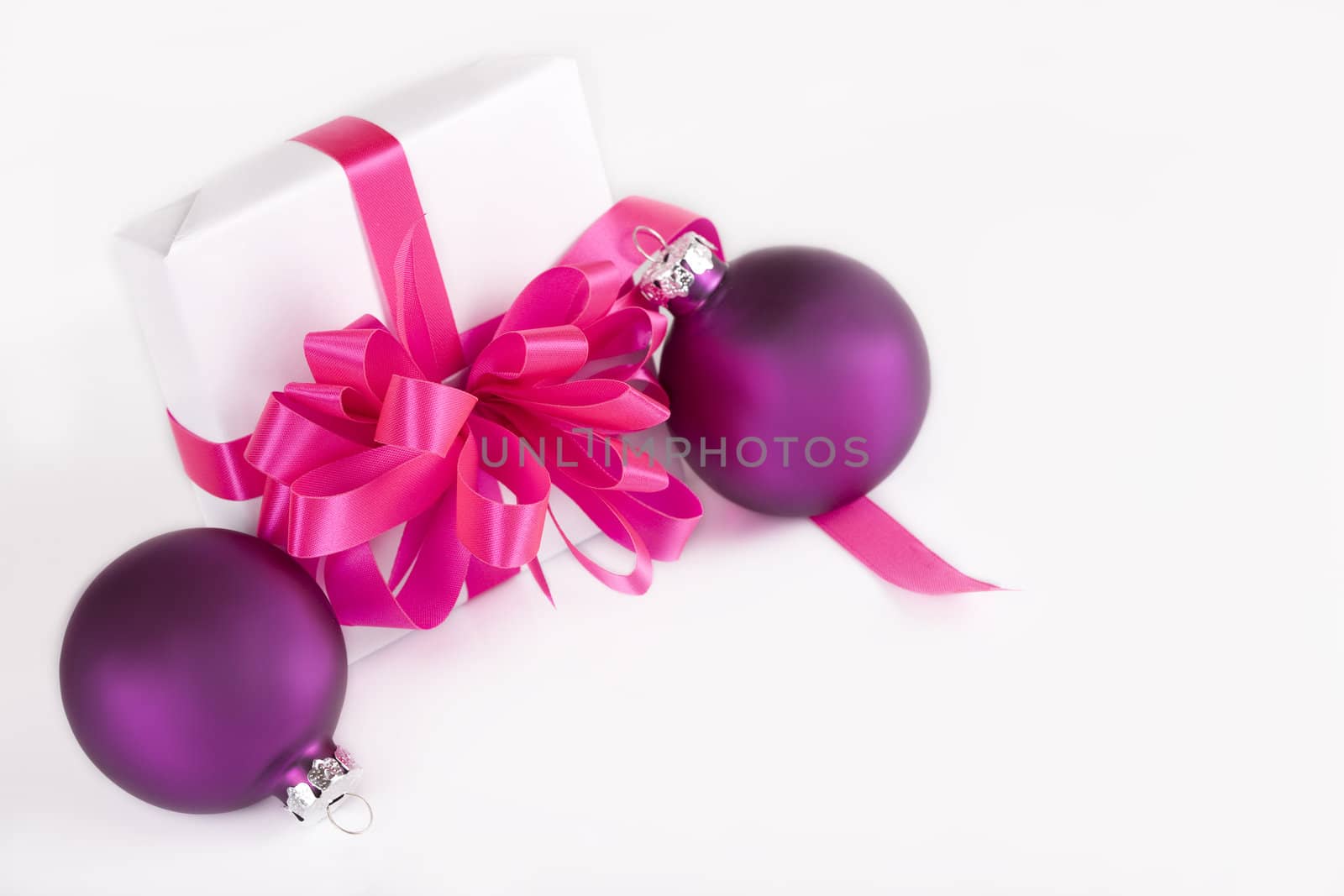 White present with pink ribbons and purple ornaments, isolated