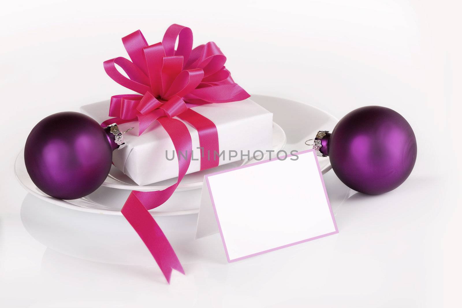 White present with pink ribbons and purple ornaments, isolated with blank name card