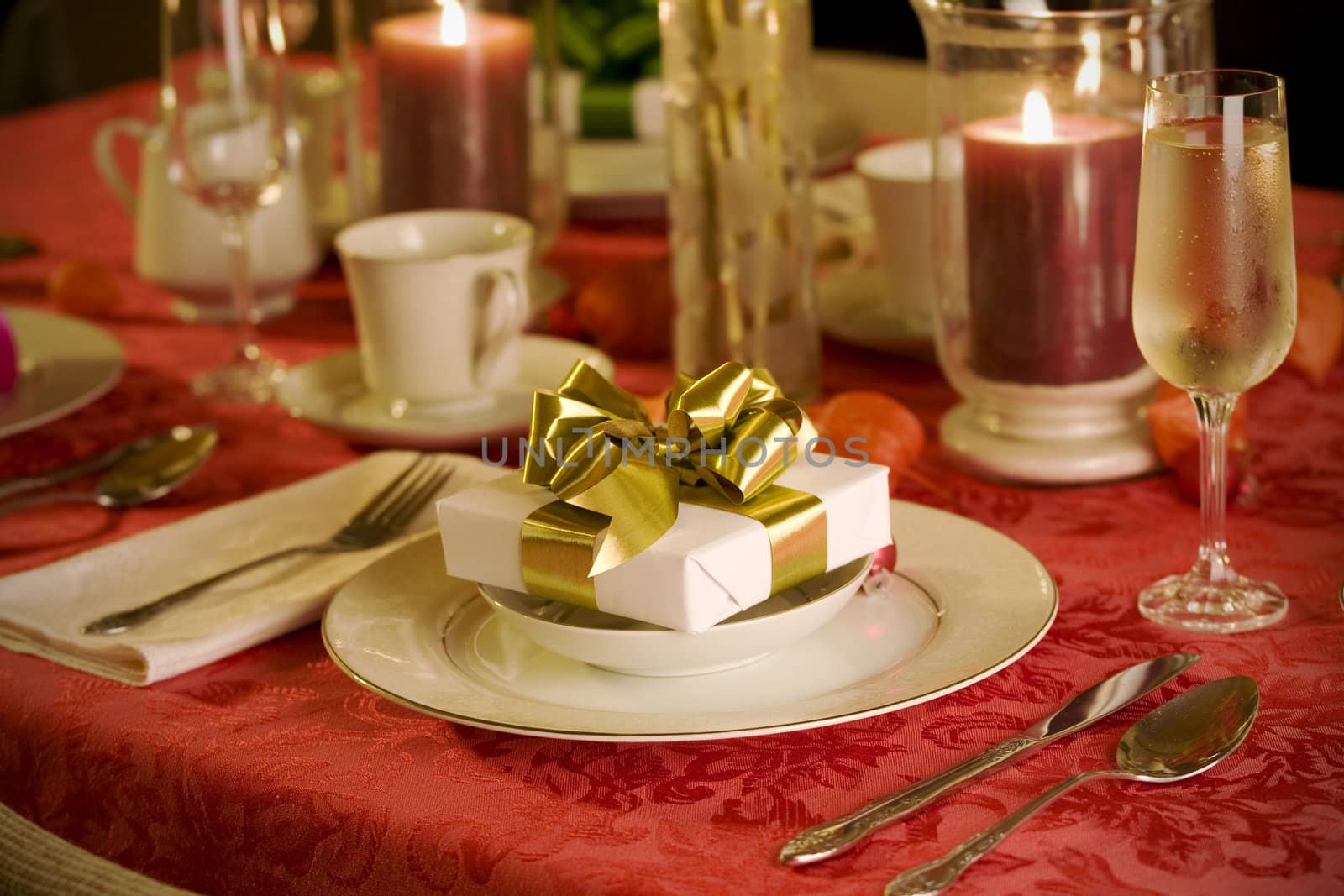 elegant Christmas table setting in red with gold gift as focal point