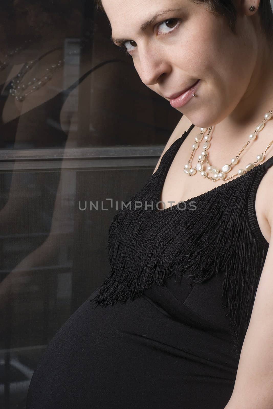 Late twentie pregnant woman in old fashion evening dress with urban background