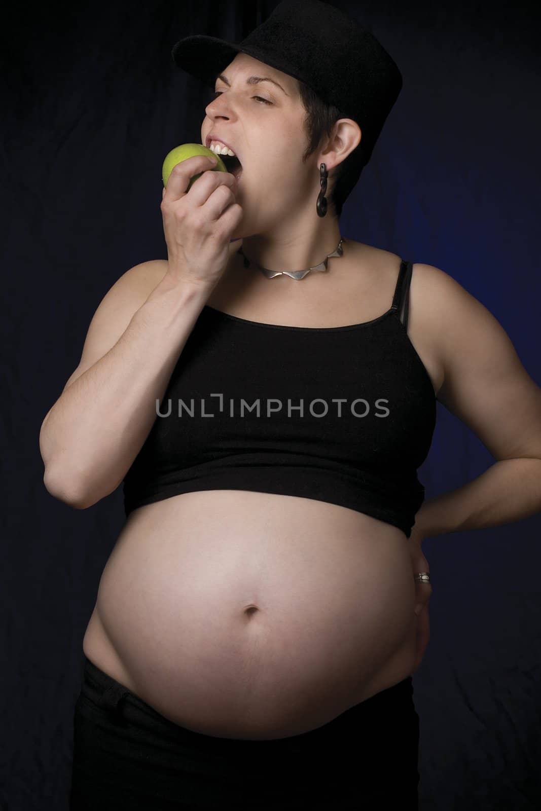 Portrait of a late twentie pregnant women eating an apple