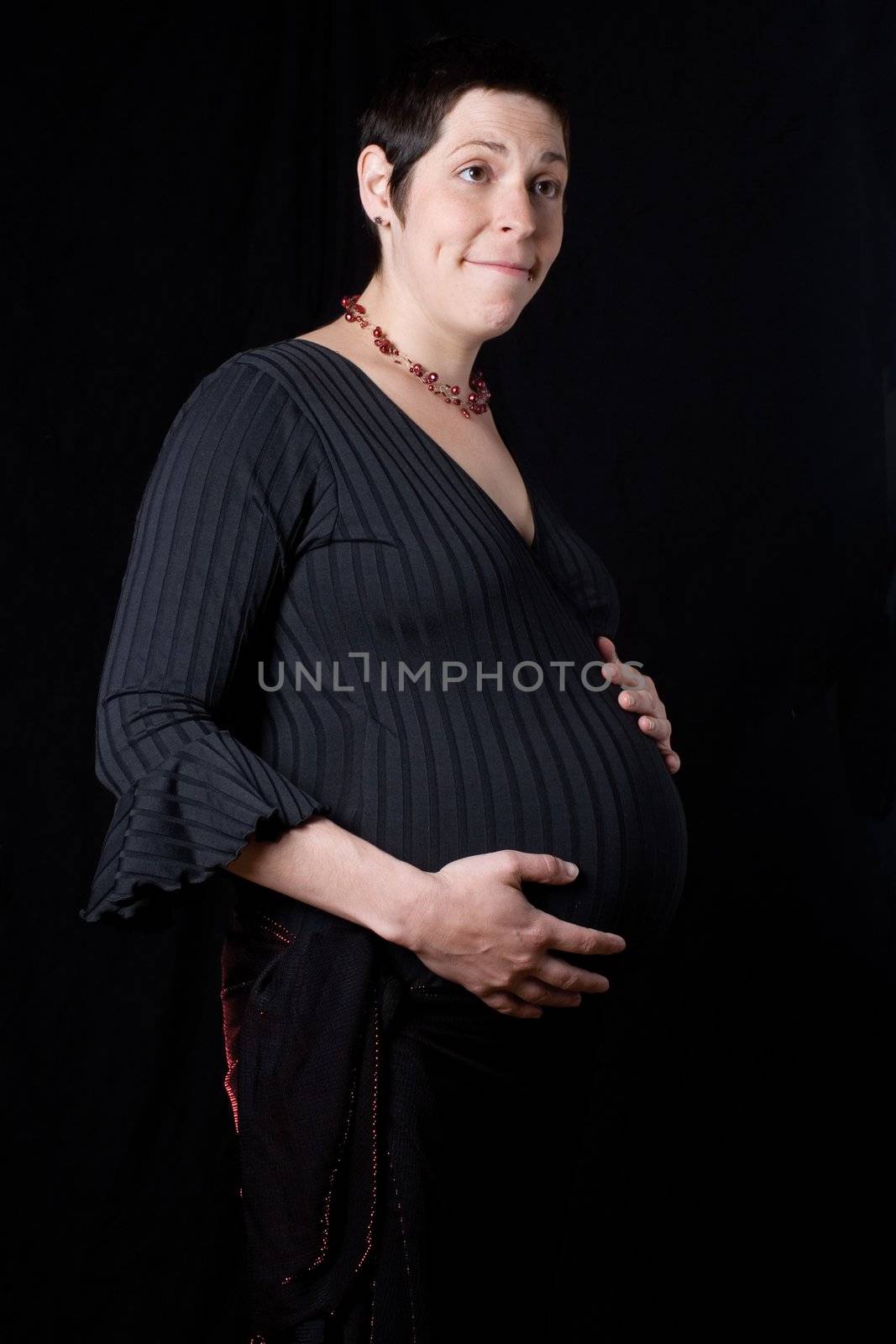 Pregnant women with sparkly skirt holding her belly giving a dumb found look