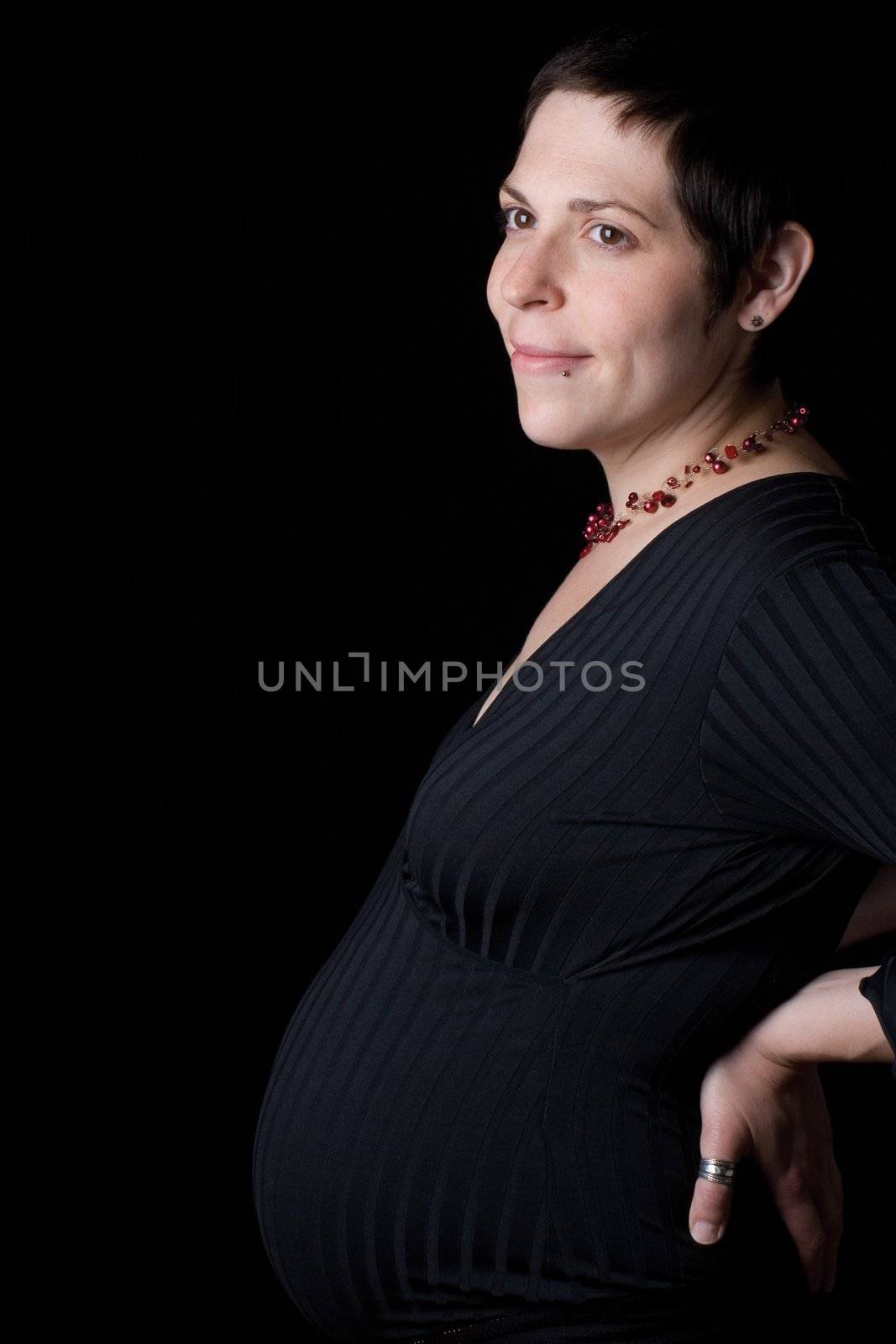 profile portrait of a late twenty pregnant women with head turn toward the camera