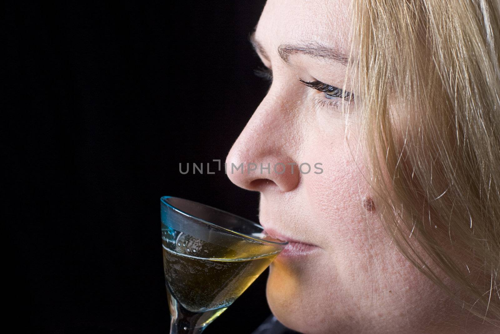 Close up portrait of a thirty something overweight women in evening clothes having a drink of brown rum