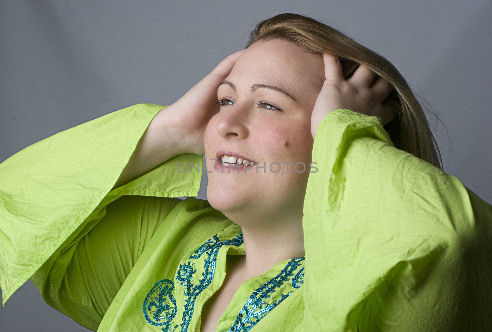 Portrait of a thirty something overweight women in casual clothes flipping the back of her hair with her hand