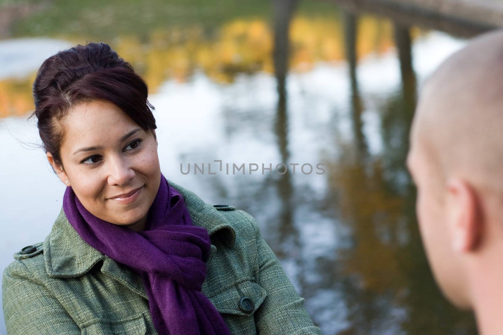 A young happy couple enjoying each others company outdoors in the fall.