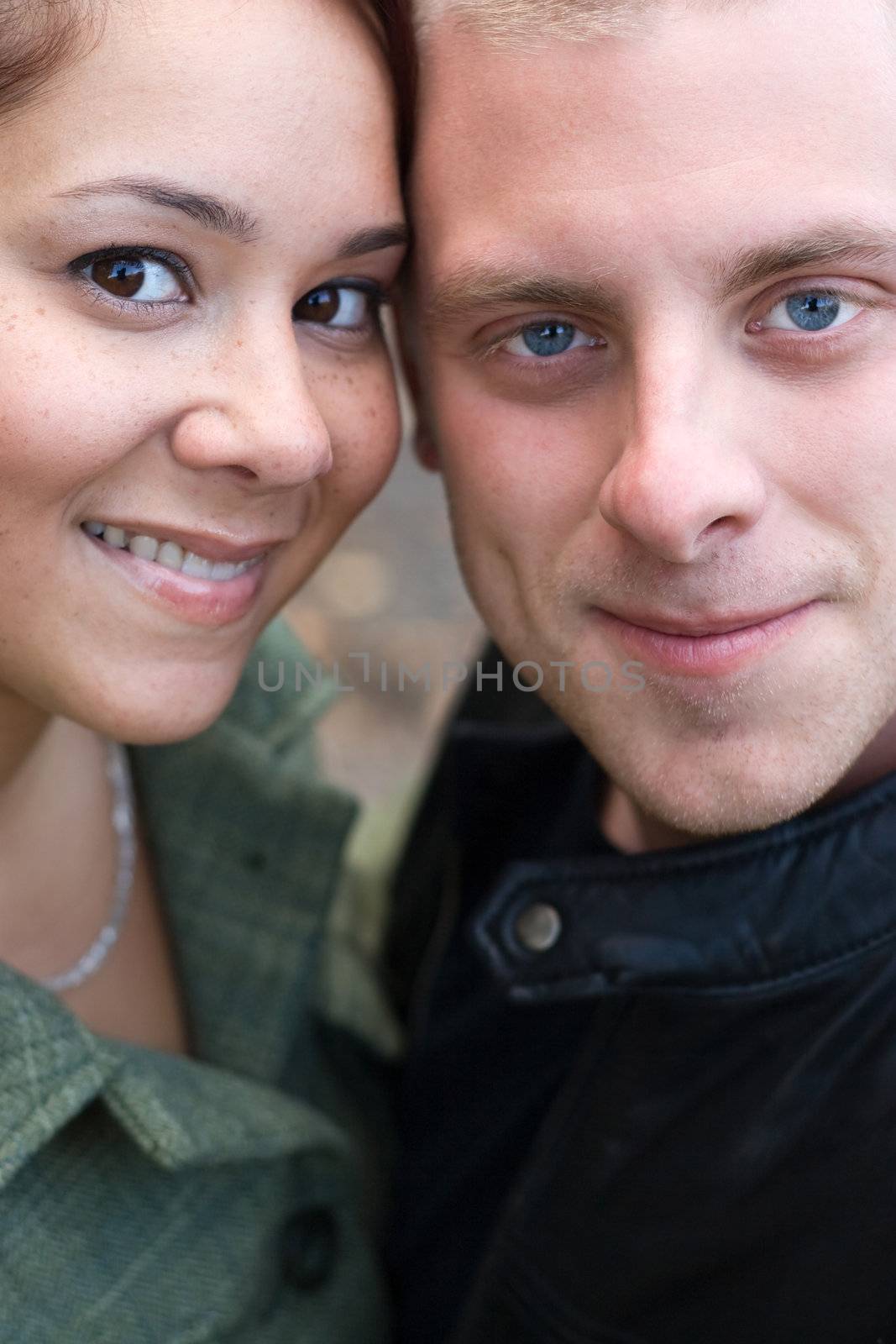 A young happy couple with their heads close together.