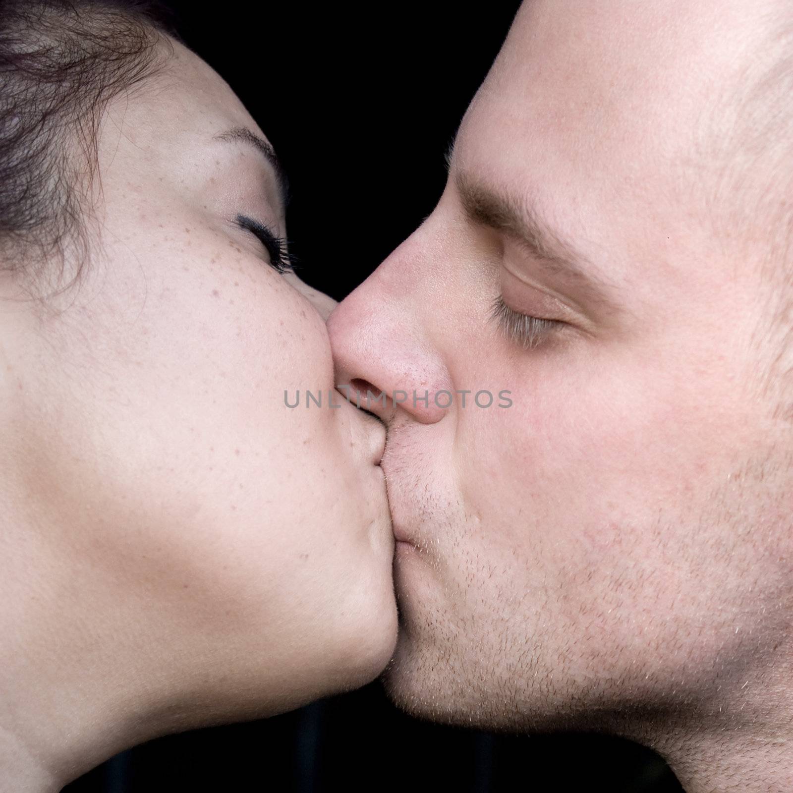 A young couple kissing each other.