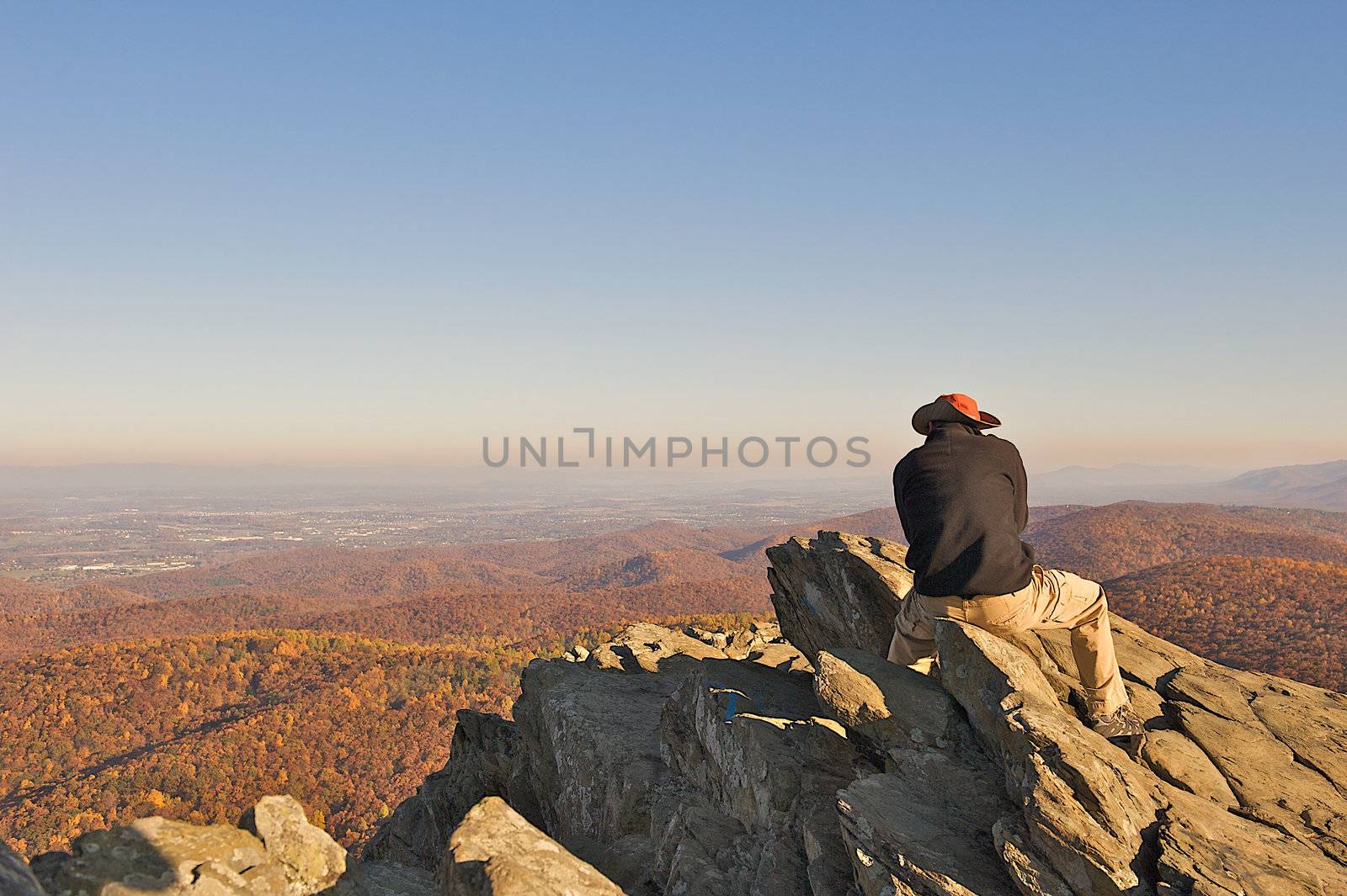 Man reflecting life while sitting on Humpback Rock in the Blue Ridge Mountains of Virgina.  The hike to this scenic overlook is about 1 mile straight up, an acheivement for any hiker.  Room for text at the top of the image.