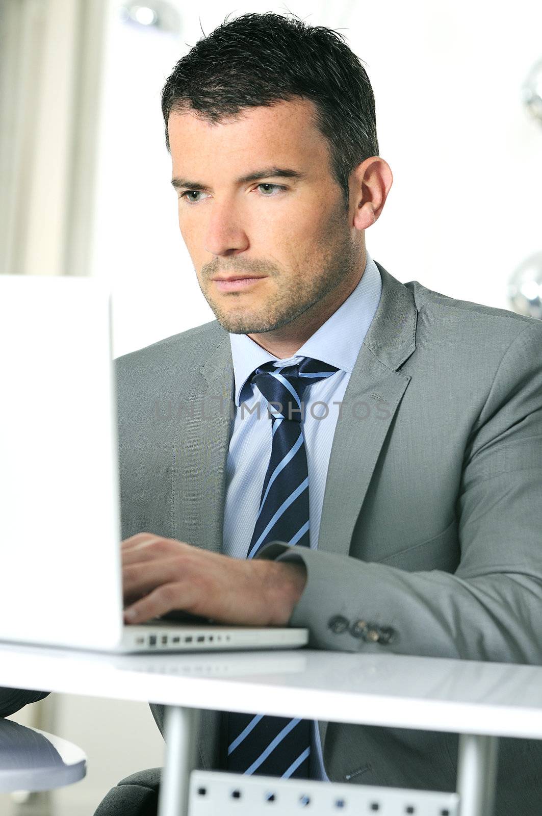 An attractive business man is working on computer