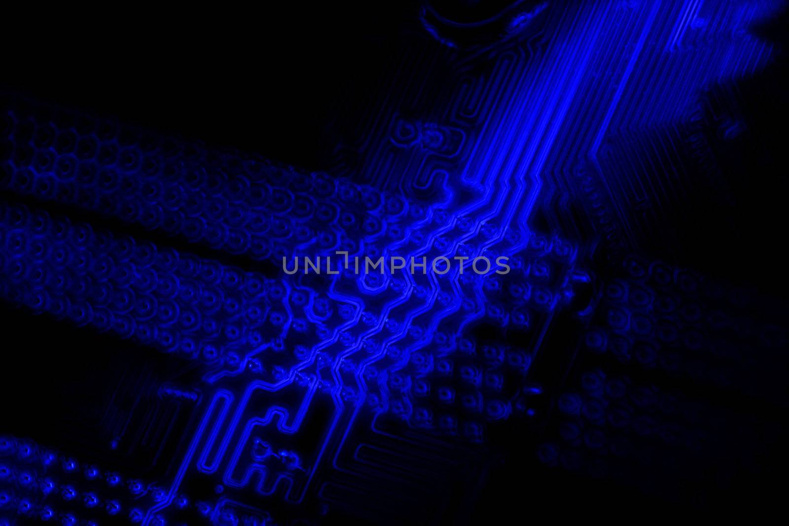 The underside of a motherboard, with a blue glow