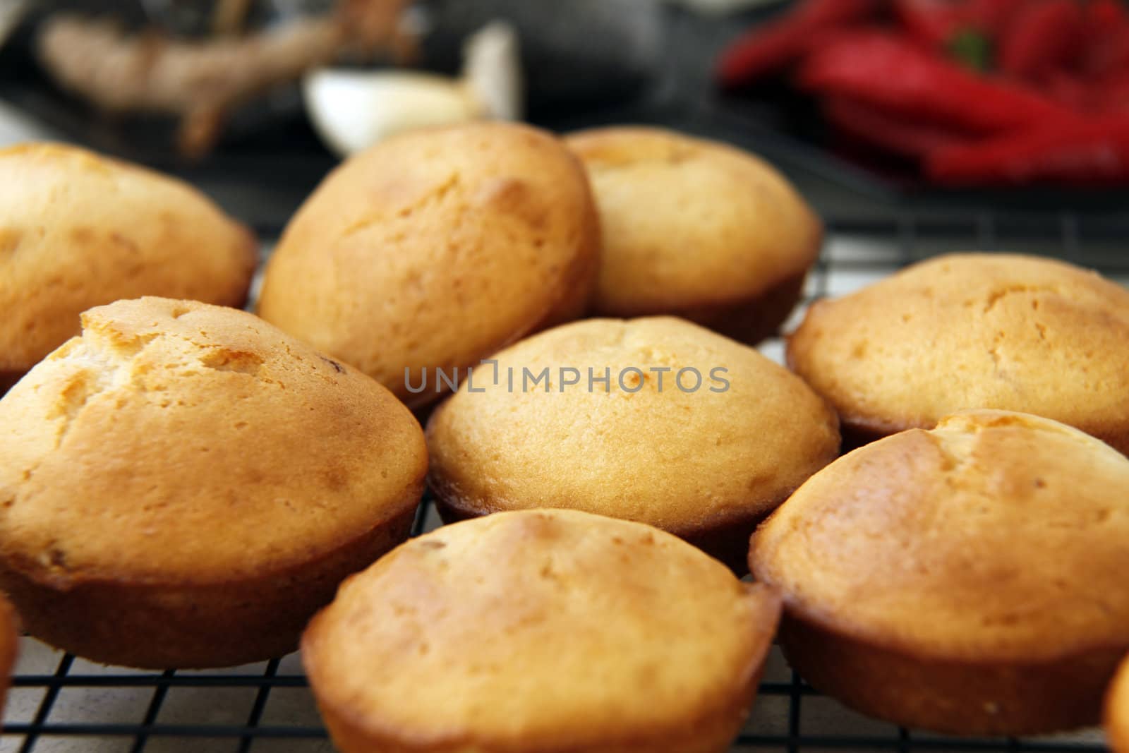 Fresh muffins sitting on a cooling tray on a normal kitchen bench.