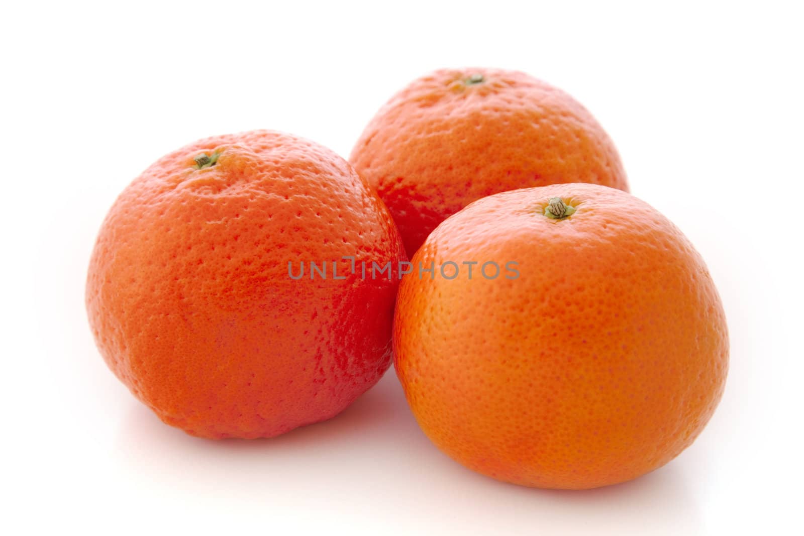 Three ripe mandarines against a white background