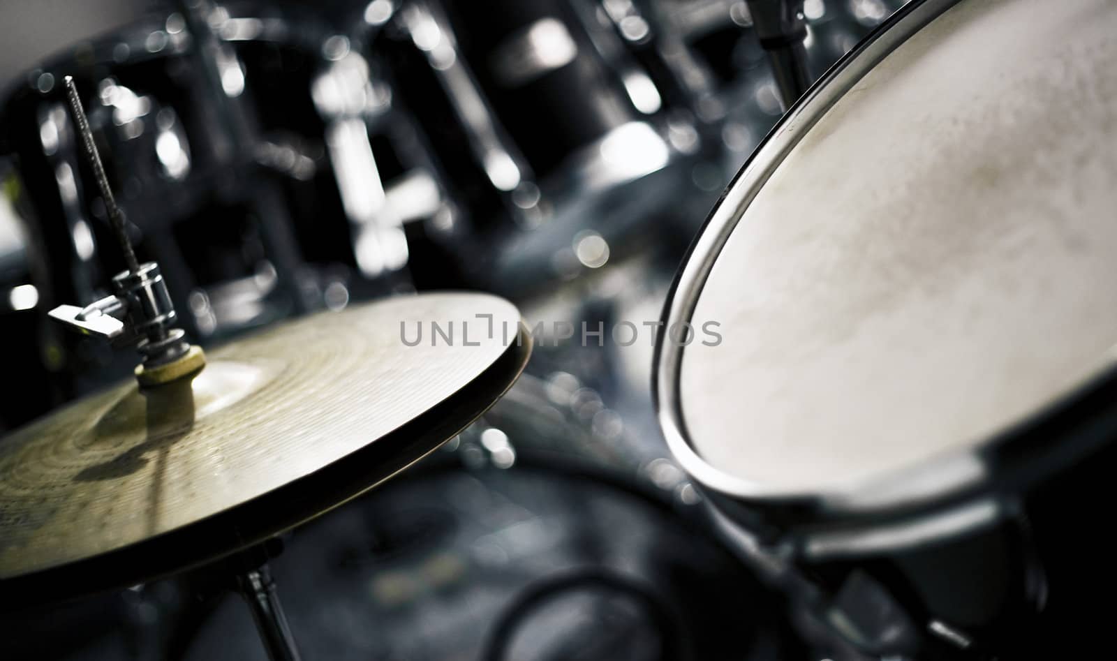 Studio shot of a hi-hat cymbal next to a tom-tom.