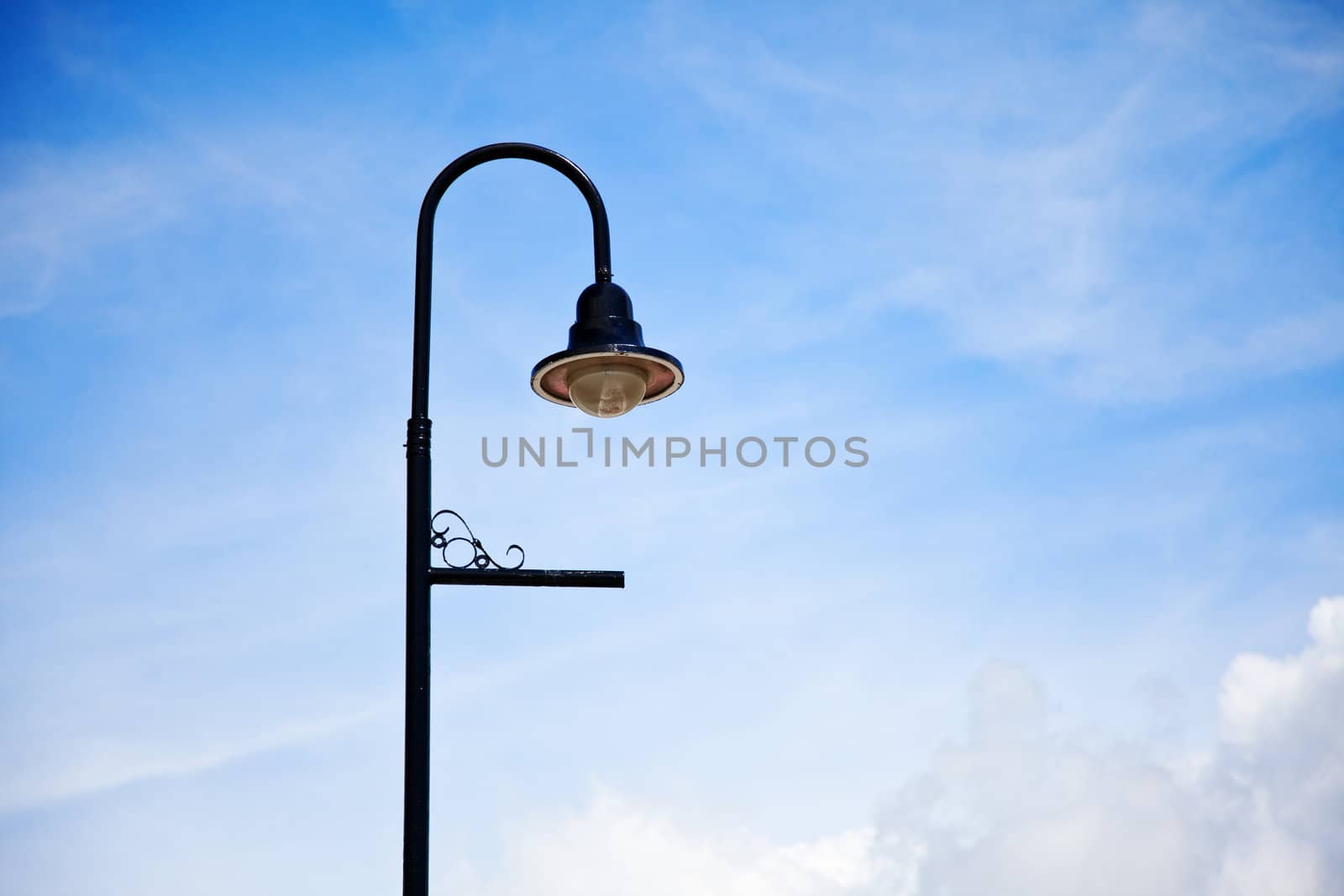 Low angle shot of an old fashioned street lamp against a beautiful blue sky.