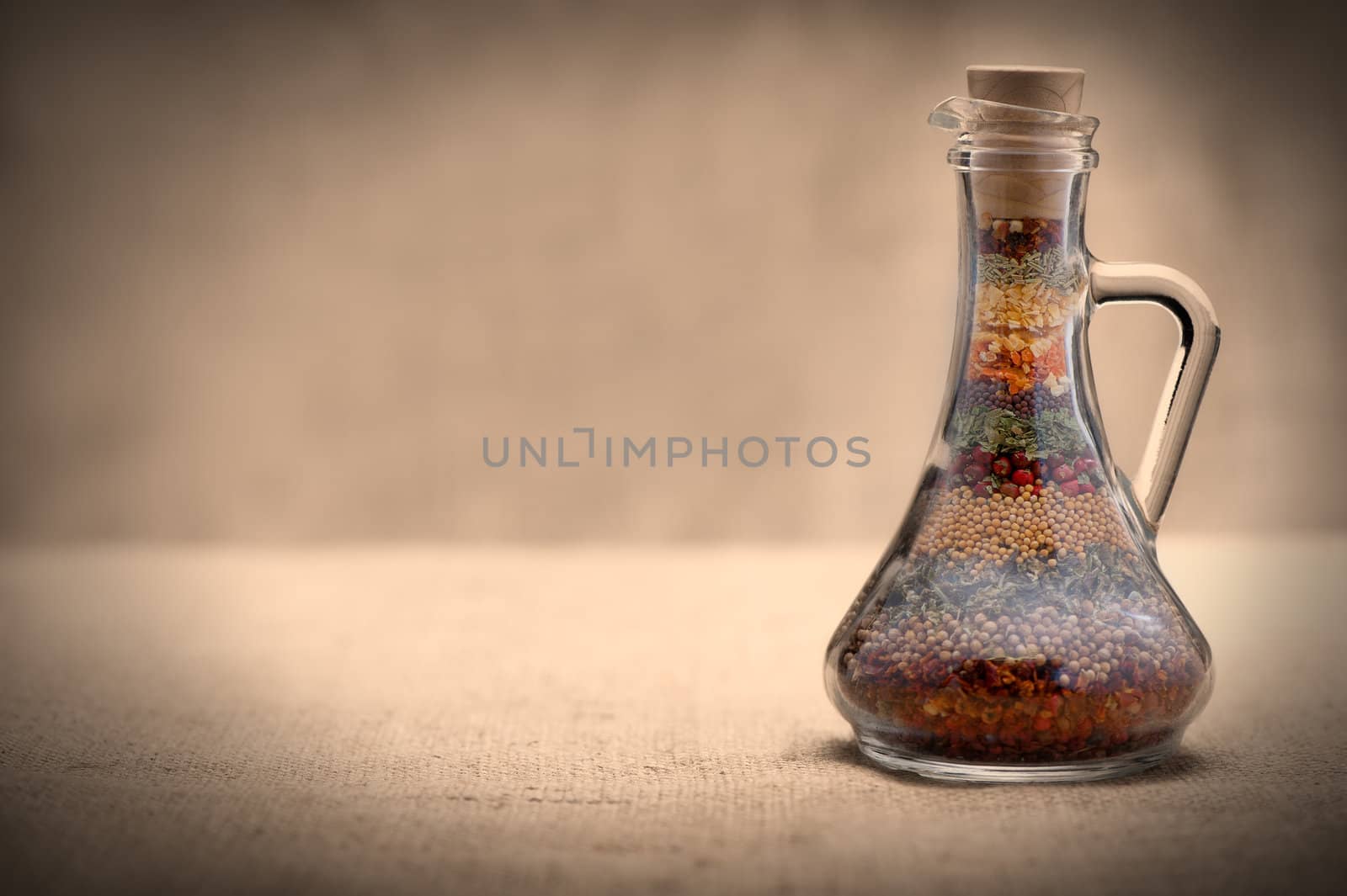 Bottle of spices. Capacity with a set of various spices on a rough background.