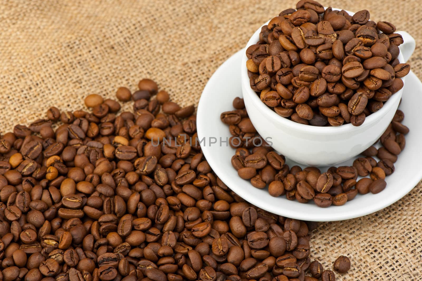 White cup with coffee grains. Grunge background