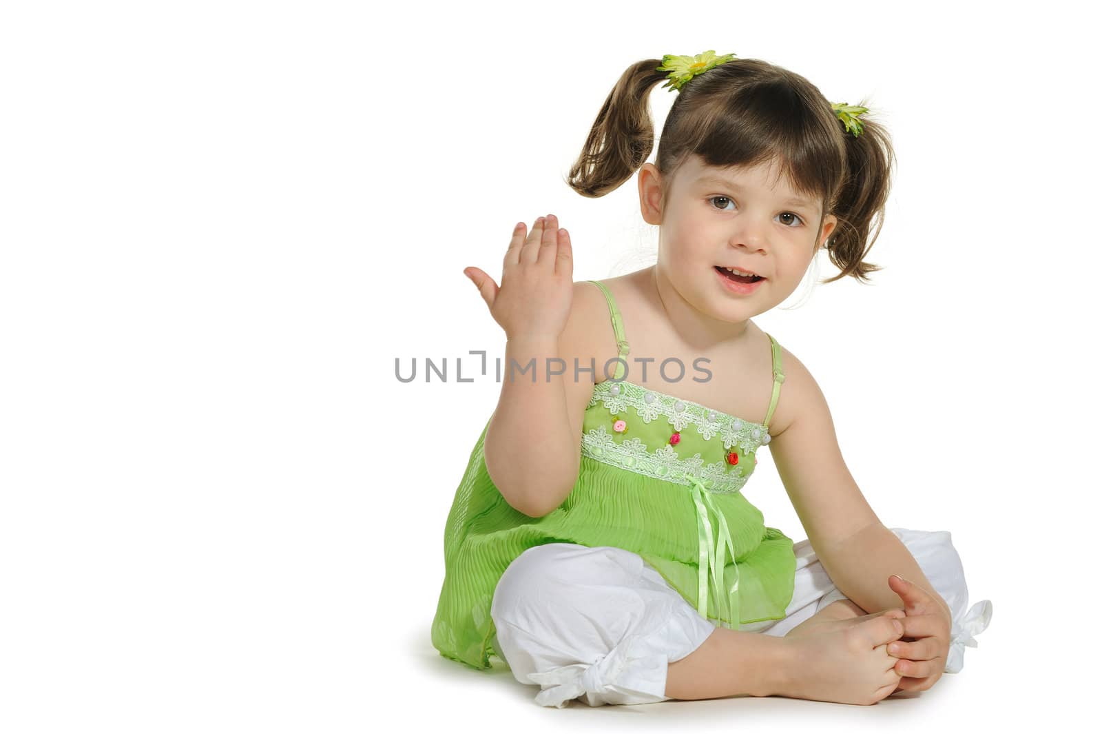 Pretty the little girl sits on the white. It is isolated on a white background