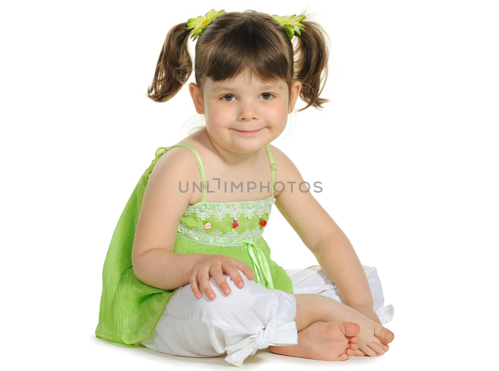 Pretty the little girl sits on the white. It is isolated on a white background