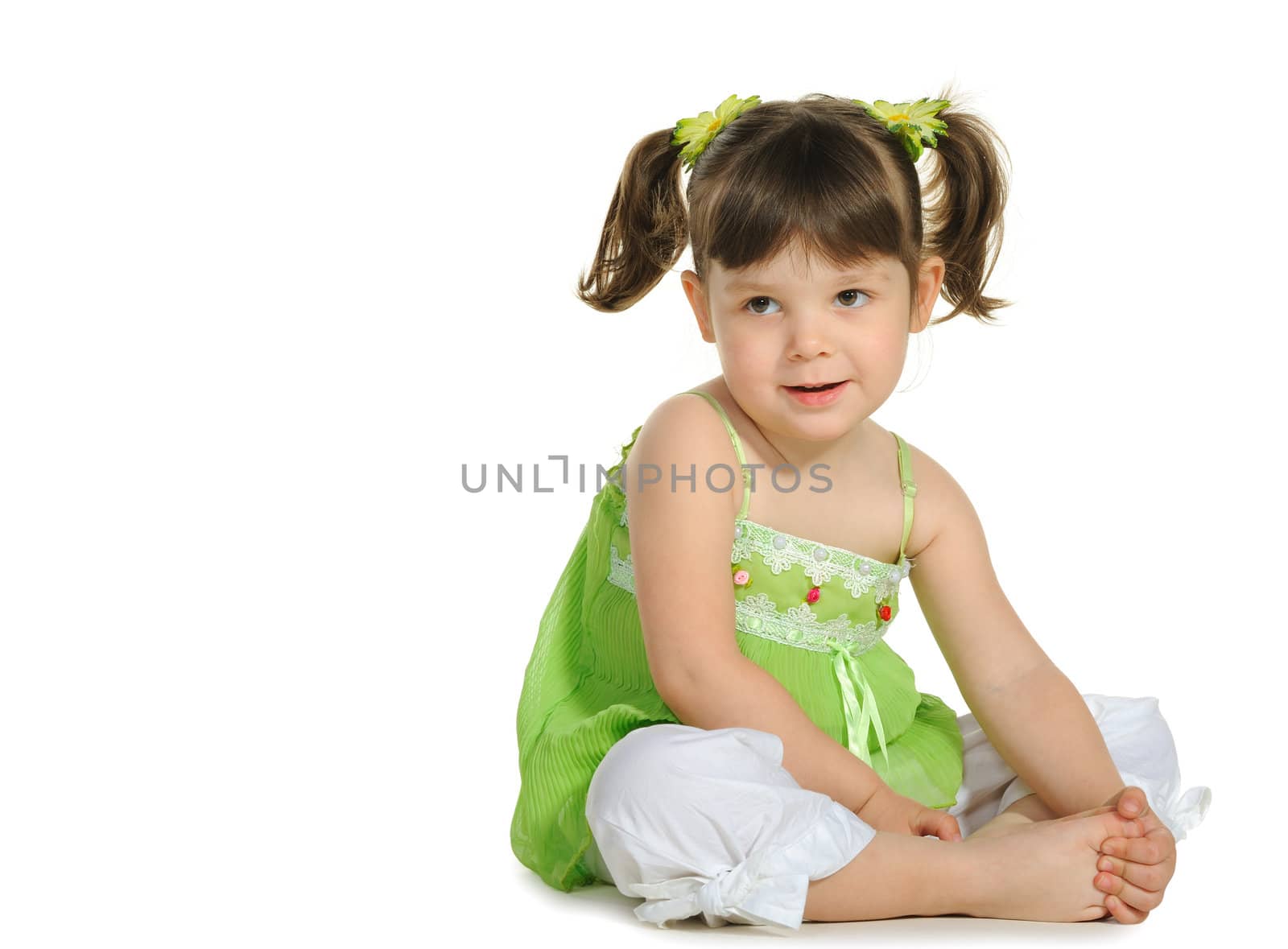 Pretty the little girl sits on the white. It is isolated on a white background