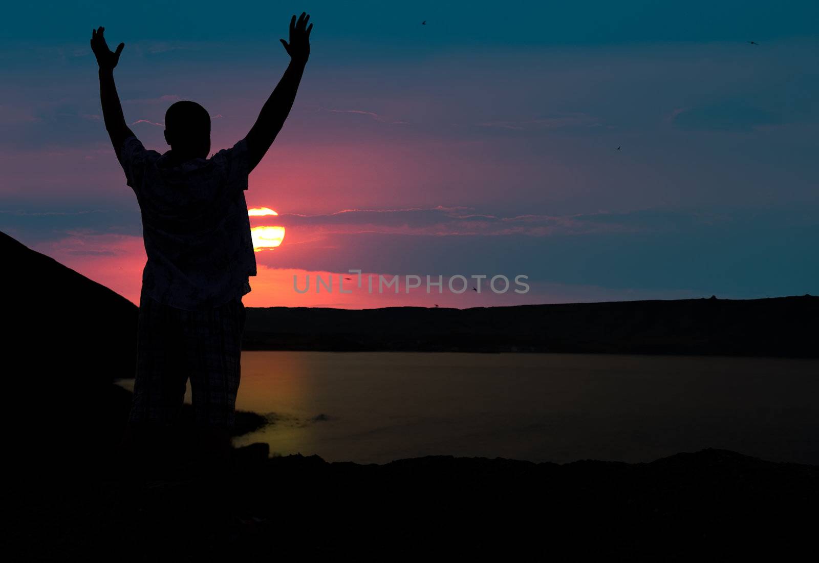 The man welcomes the sunset sun. Upwards the lifted hands