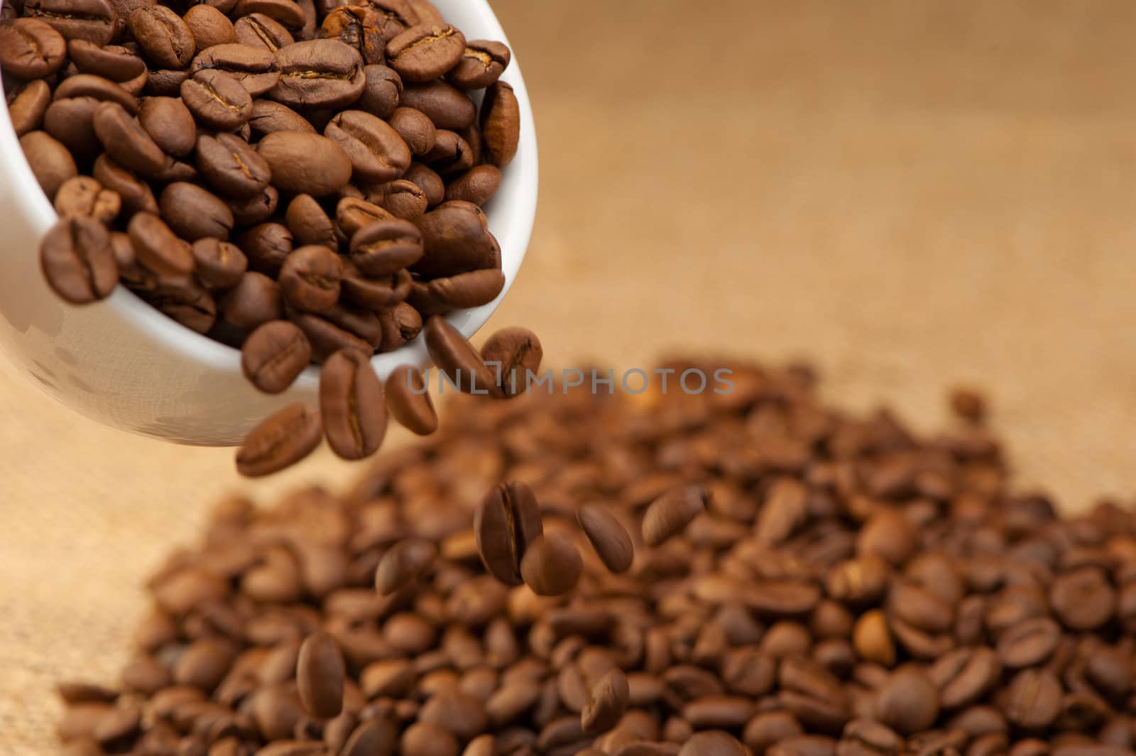 Coffee grains fall from a cup. Photo closeup