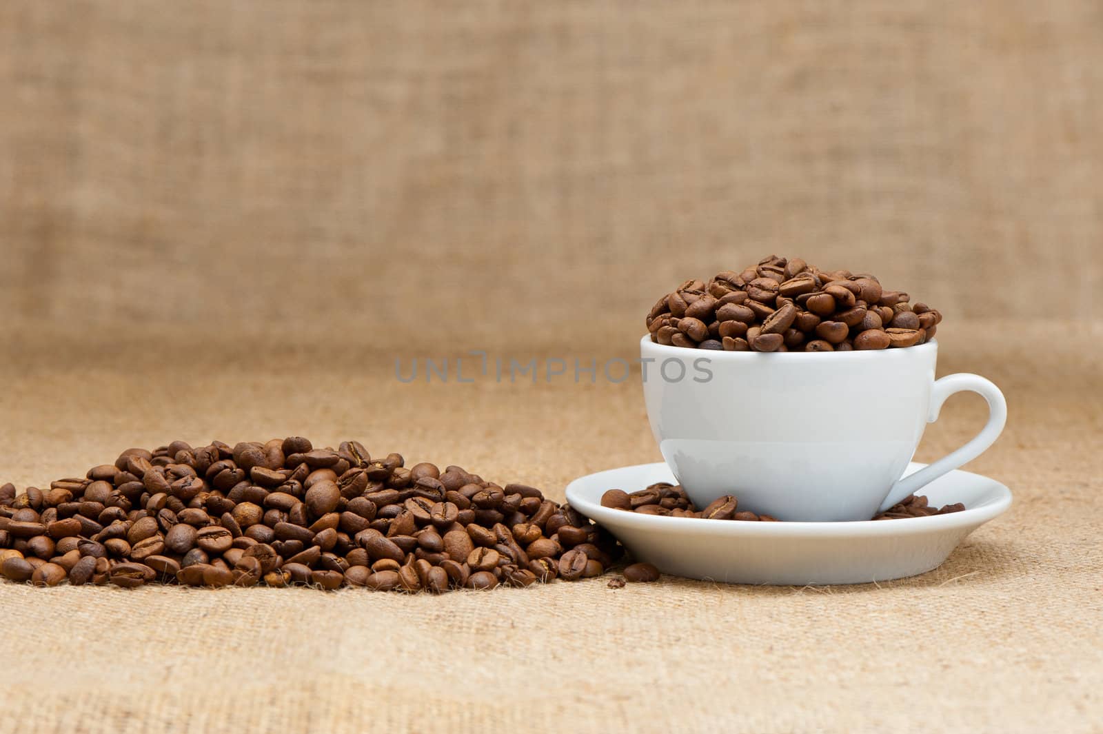 White cup with coffee grains. Grunge background