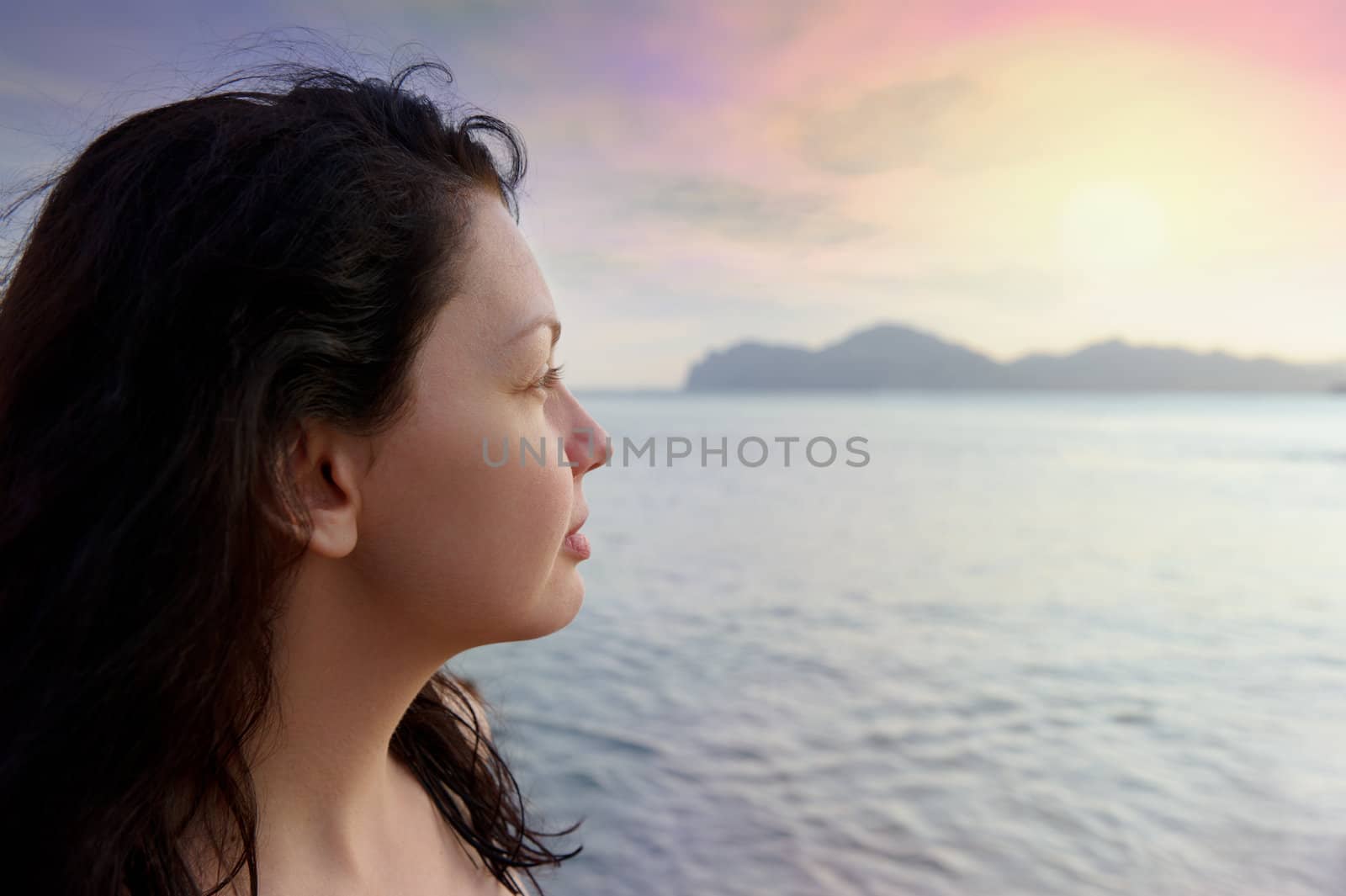 The attractive woman on seacoast and beautiful sunset by galdzer