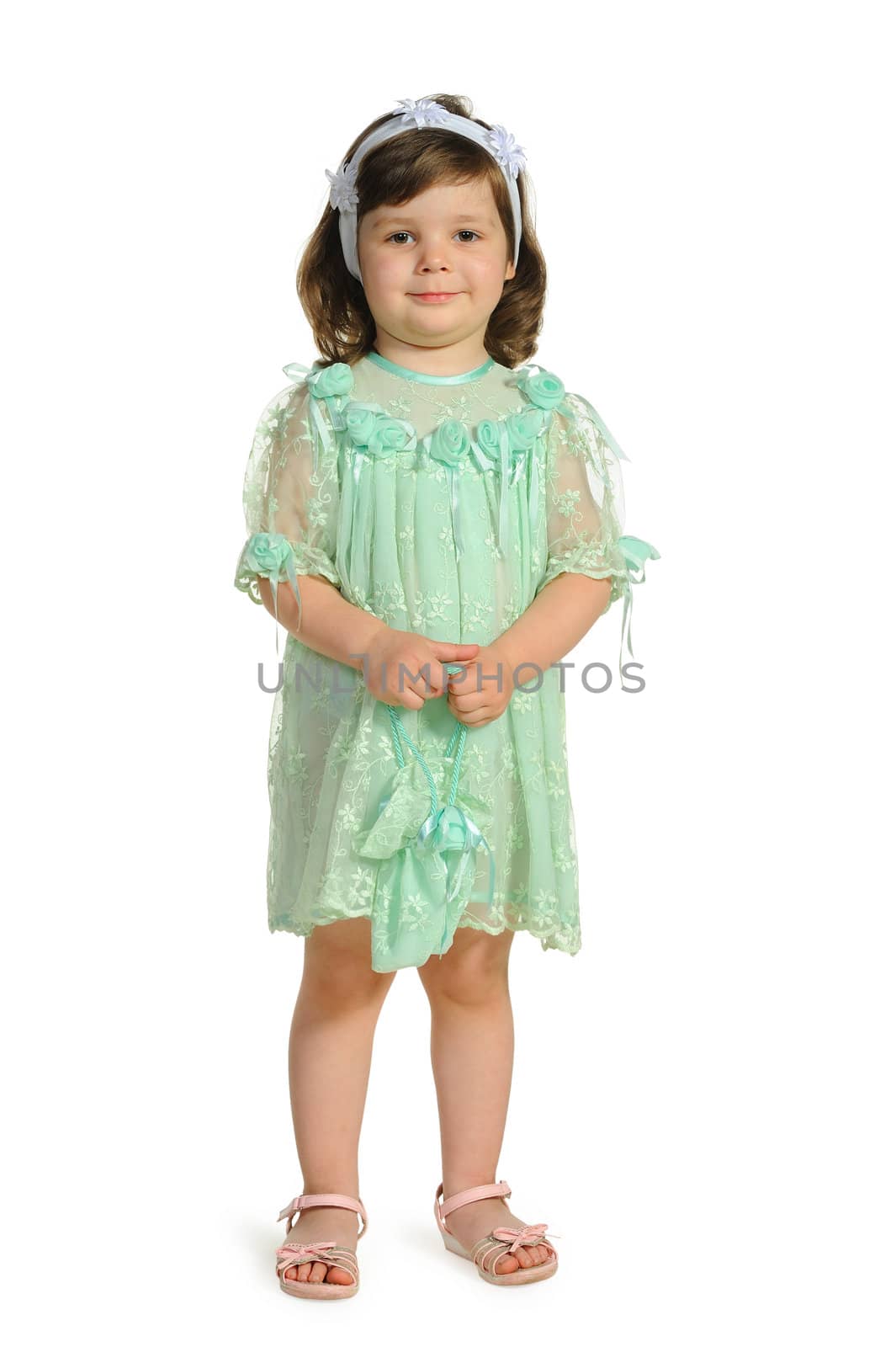 The lovely little girl in a green dress. It is isolated on a white background