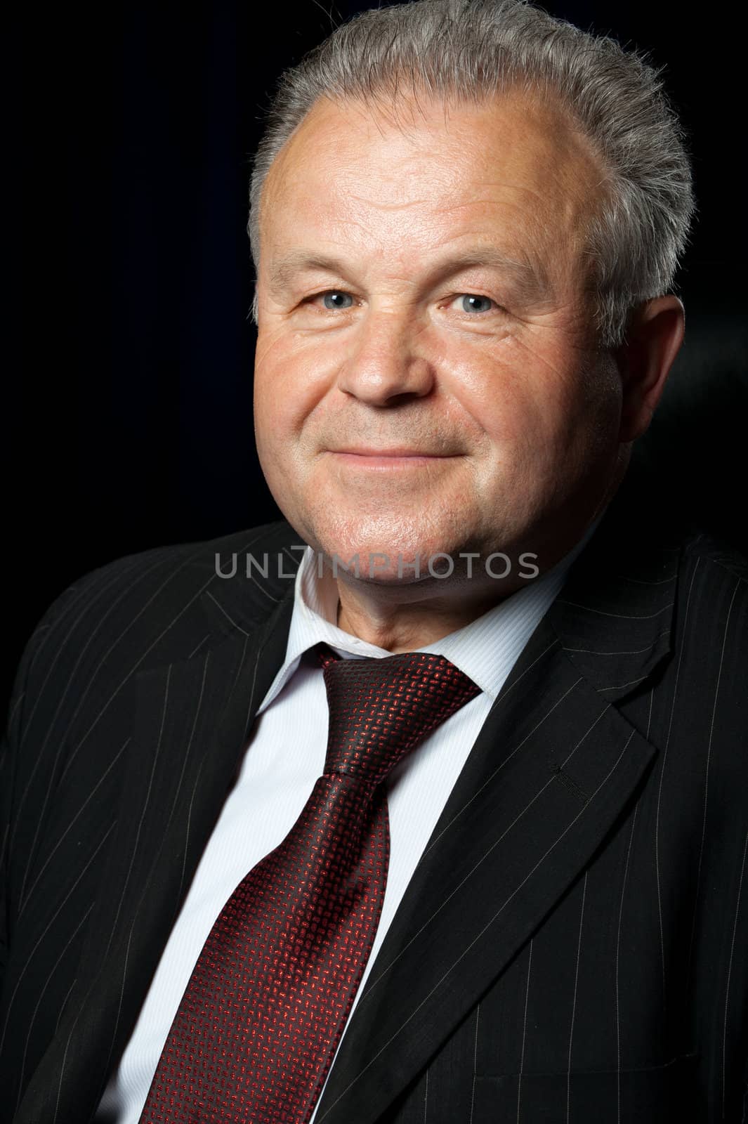 Portrait of the elderly man. A photo against a dark background