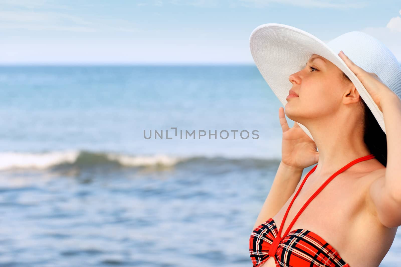 The girl in a hat against the sea and blue sky by galdzer