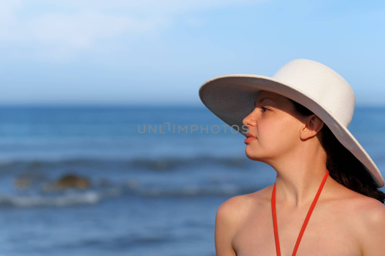 The girl in a hat against the sea and blue sky by galdzer