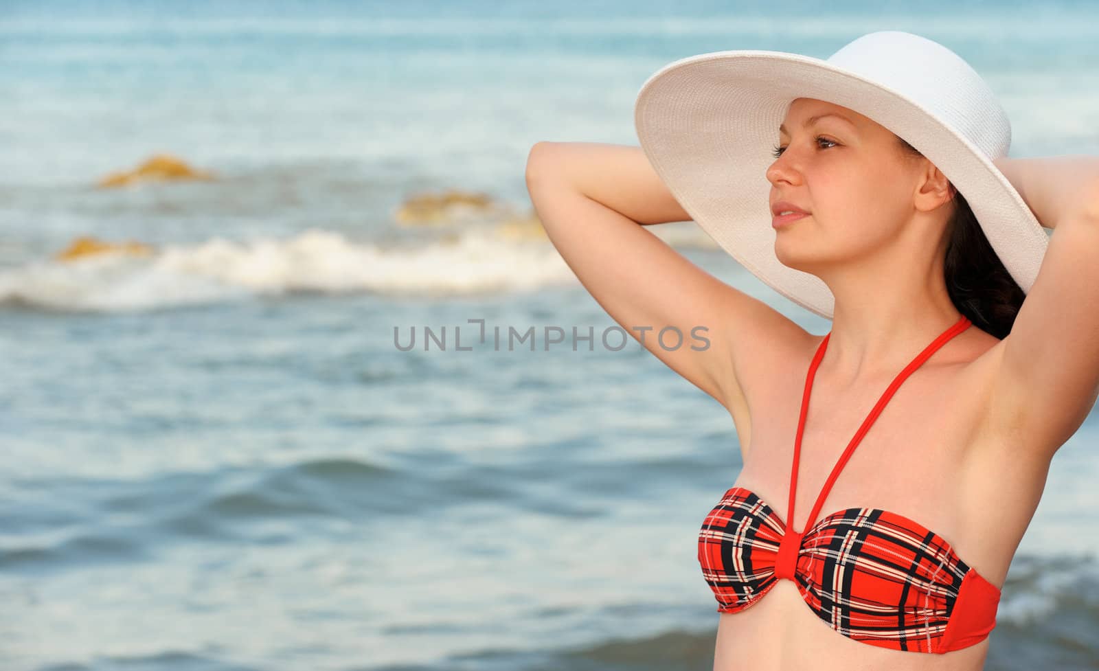 The girl in a hat against the sea 