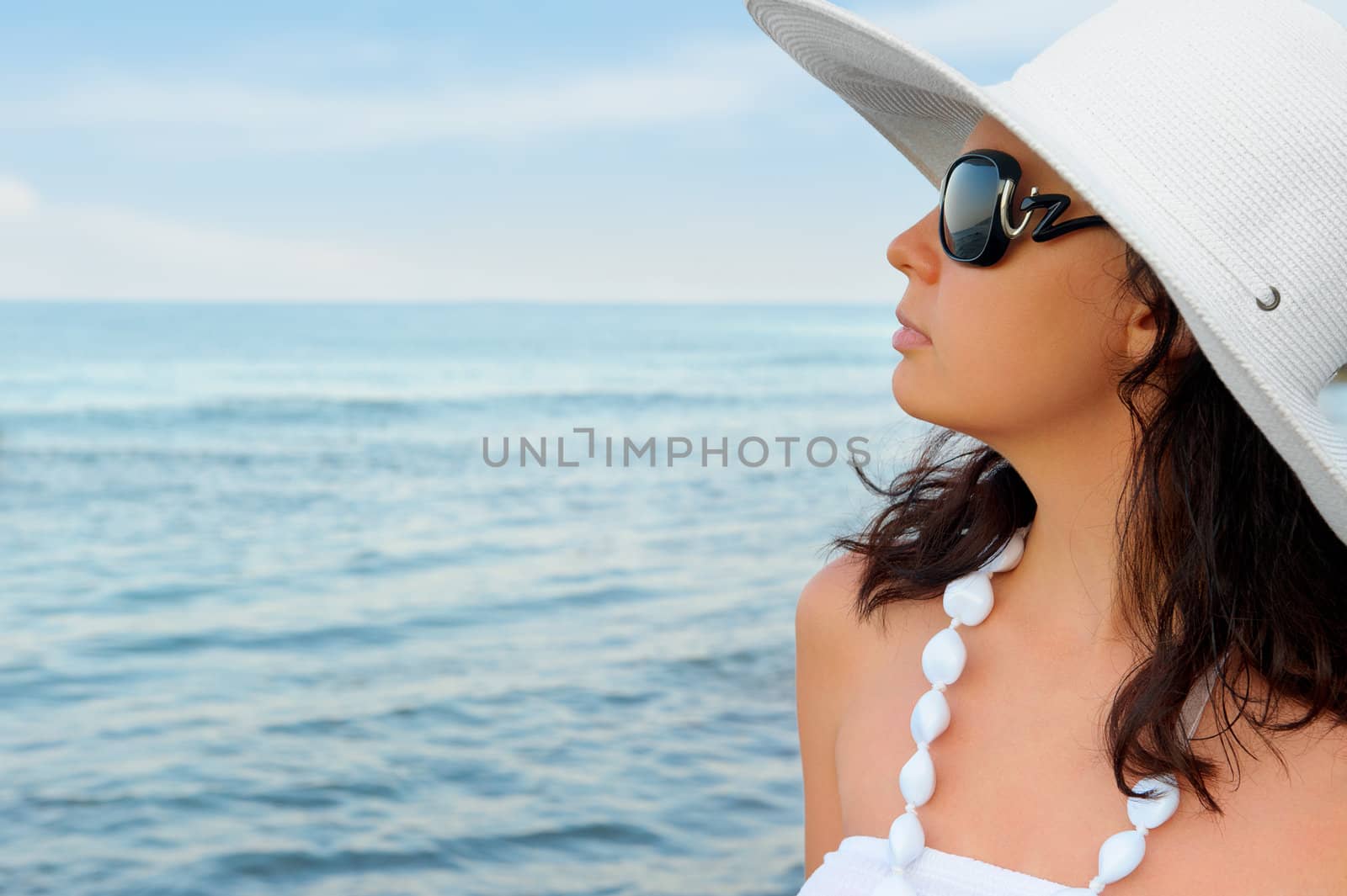 Portrait of the young woman in a hat. Seacoast, a close up