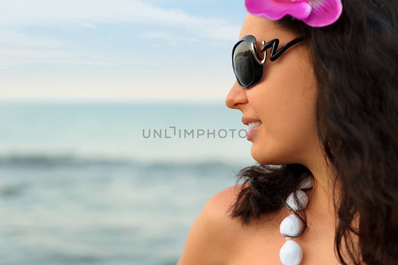 Portrait of the beautiful woman on seacoast. A profile, sun glasses