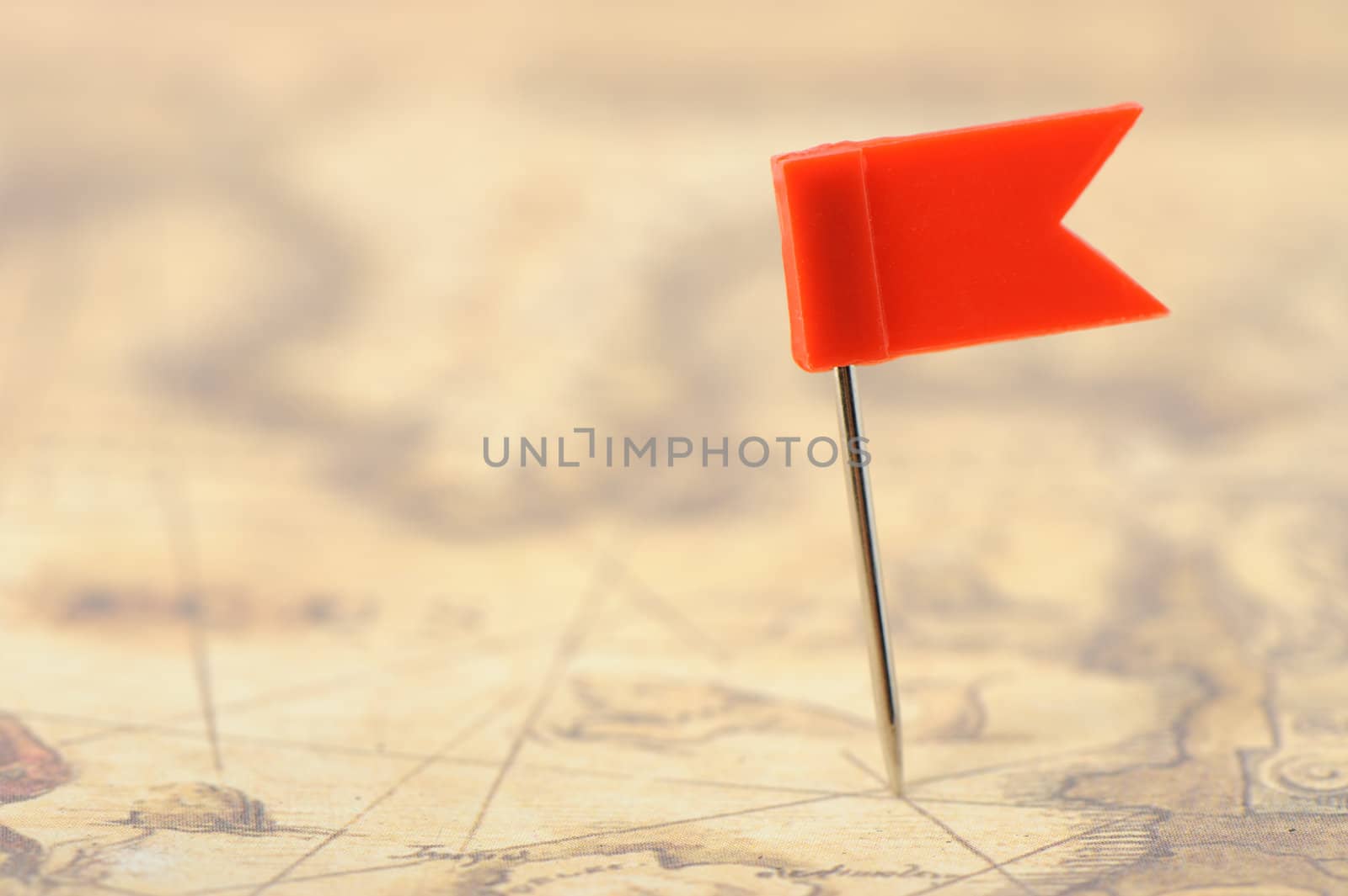 Flag red a pin on old map. Photo closeup. Selective focus