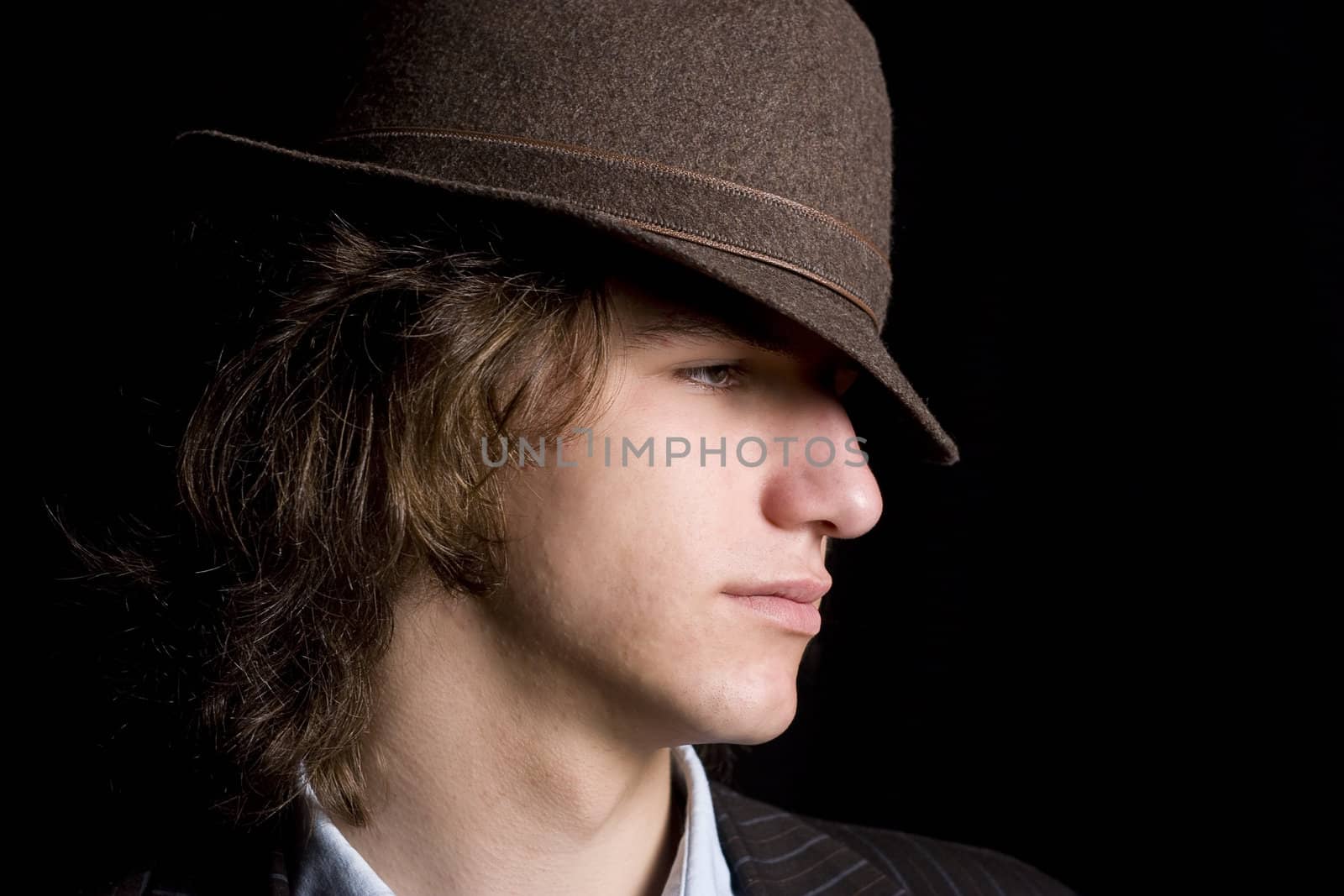Male teenager wearing a suit and hat with mad expression