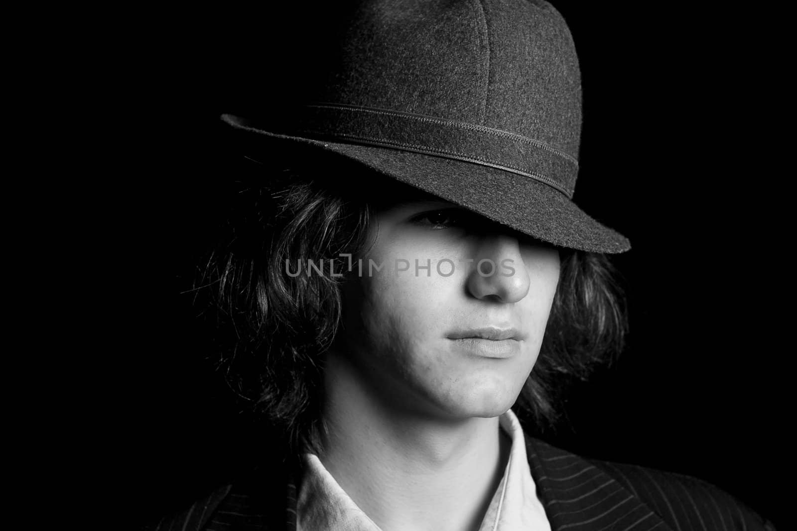 Male teenager wearing a suit and hat with sad expression