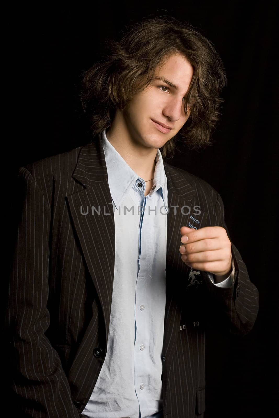 Male teen wearing a casual suit with strain of hair in front of his eyes