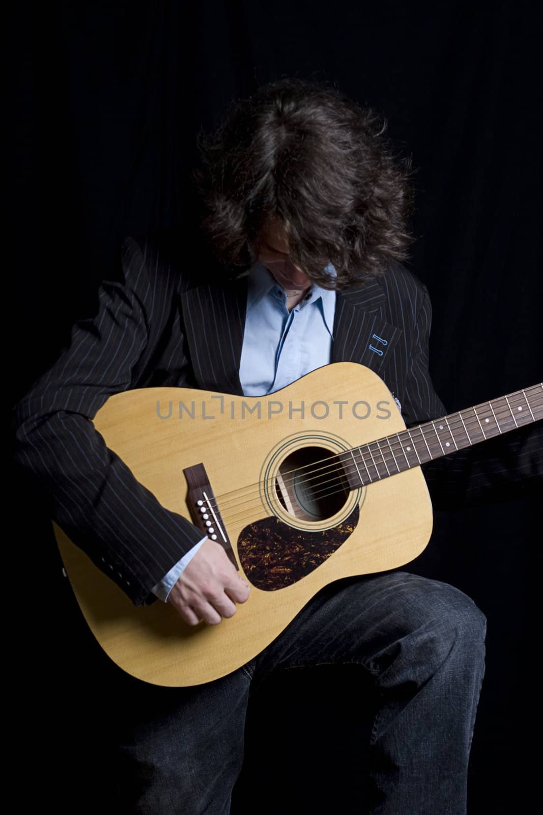 Male teenager folk guitar player bend over laughing