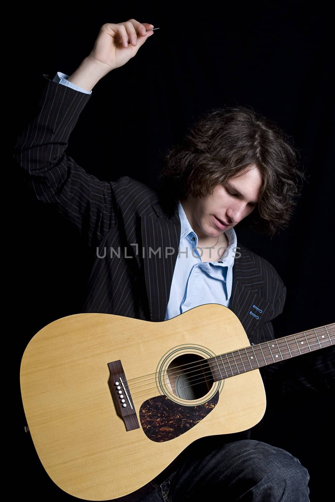 Male teenager folk guitar player about to do a big strum