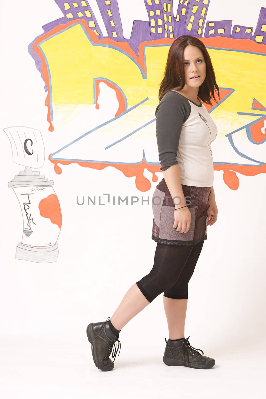 Teen girl walking in front of a graffiti