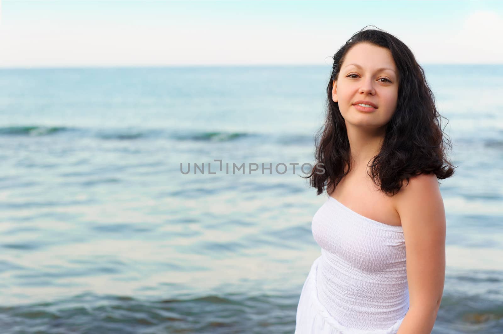 The woman in a white sundress on seacoast. A picturesque landscape