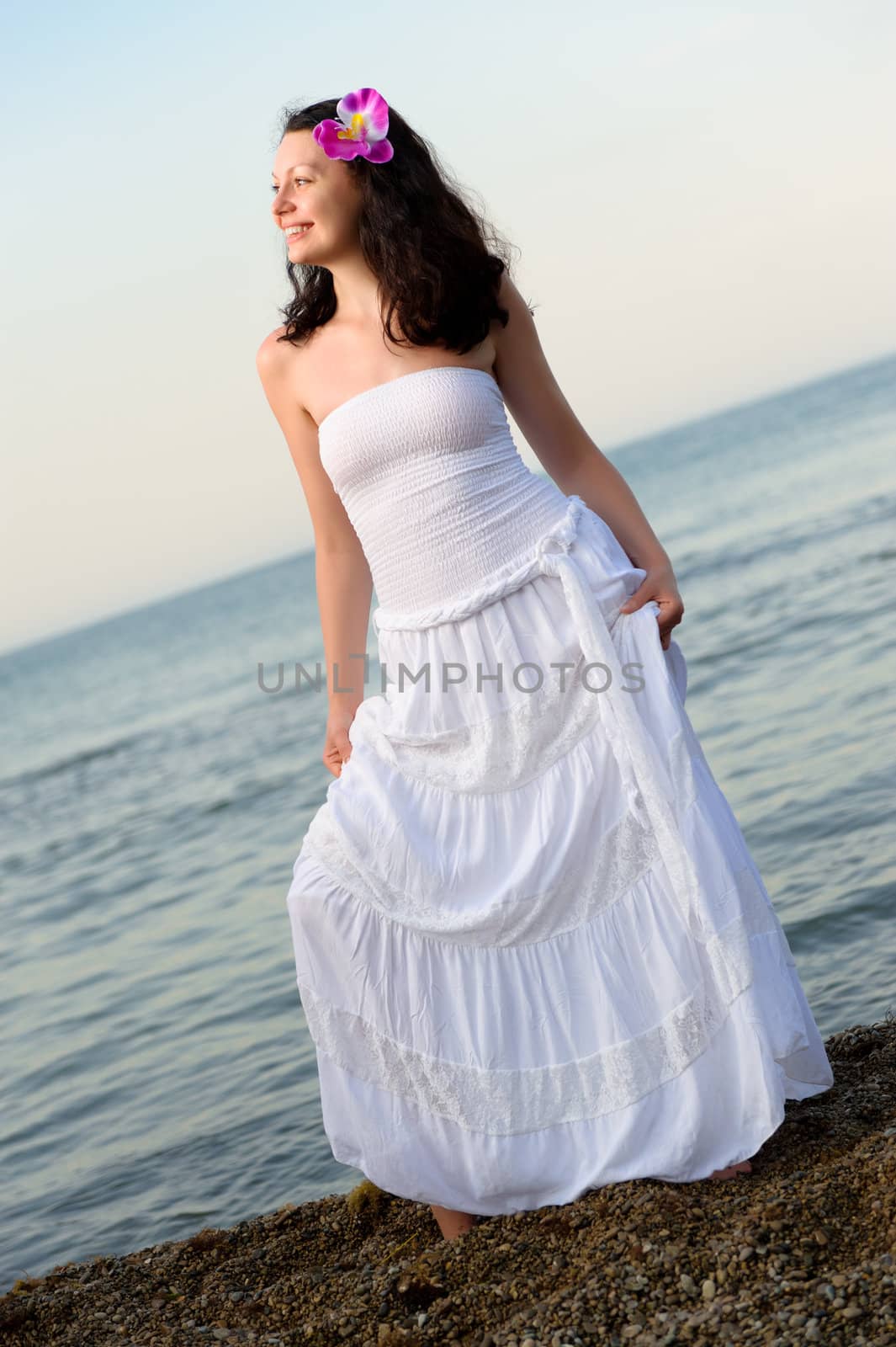 The woman in a white sundress on seacoast. by galdzer