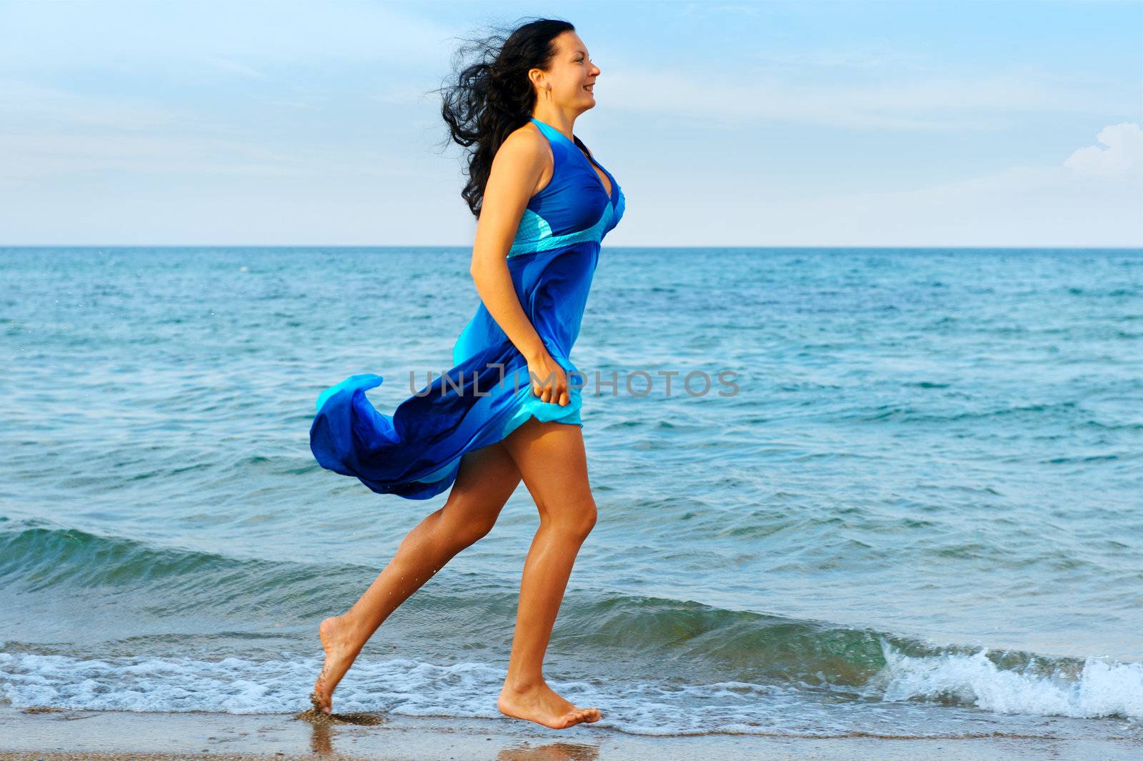 The woman runs on sea coast. A picturesque landscape