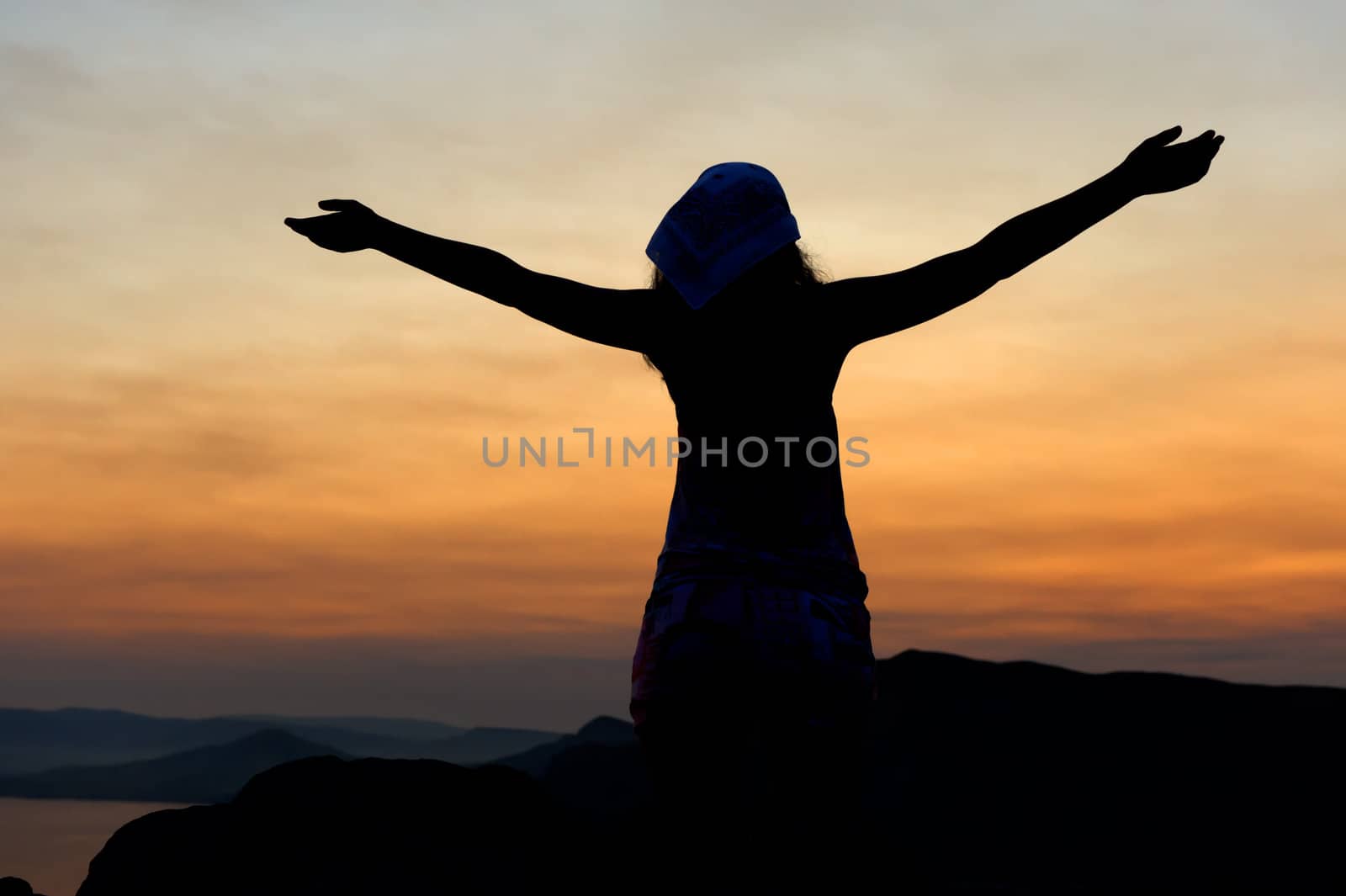 The woman on a mountain with open hands welcomes a decline
 by galdzer