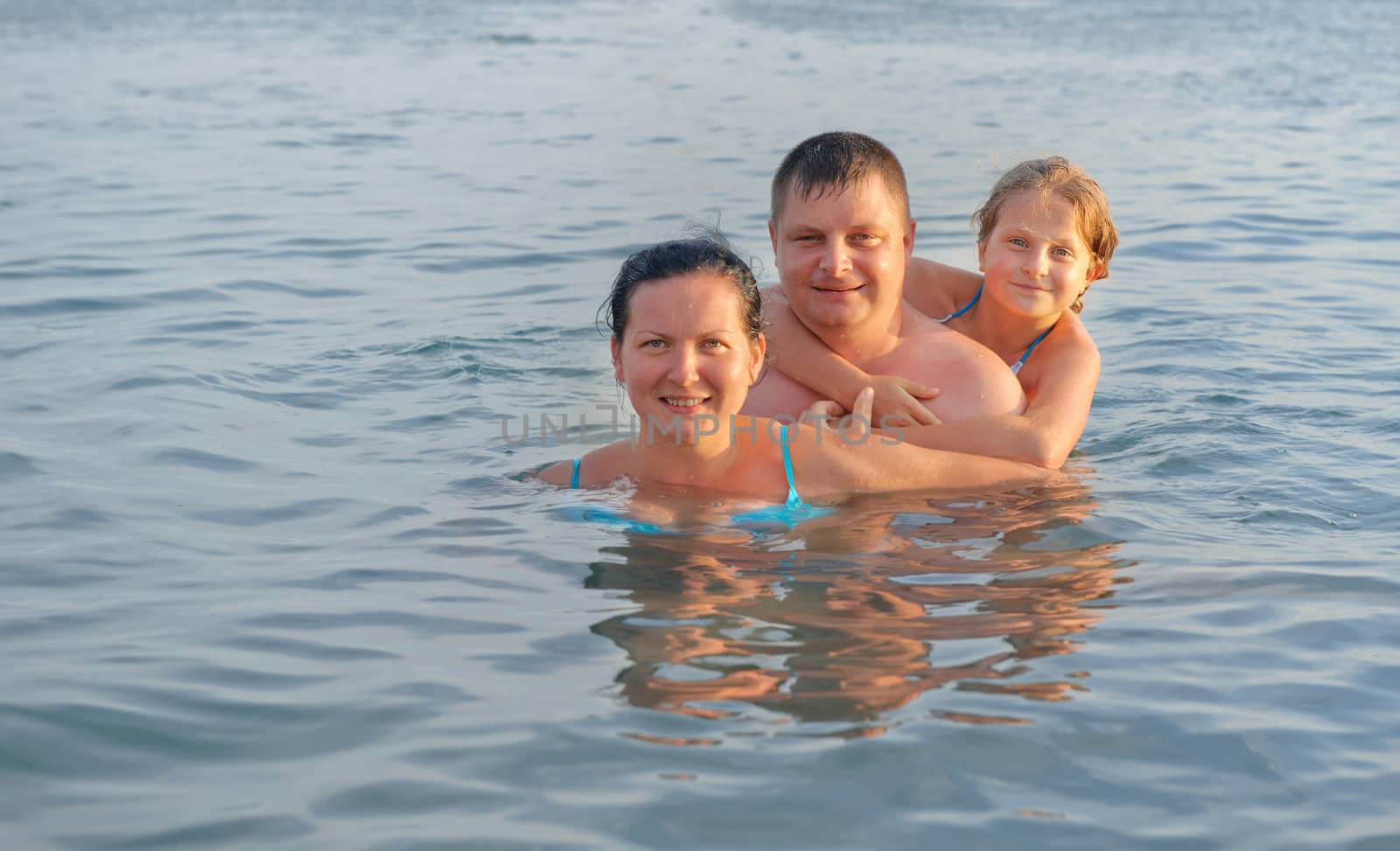 Happy family in the sea. Mum, the father and the daughter