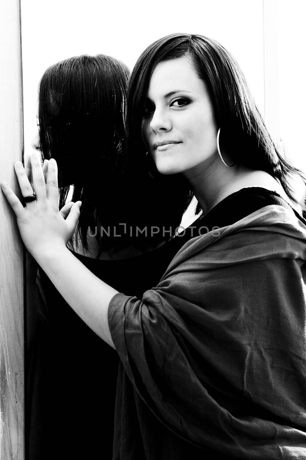 Women leaning against a mirror looking at the camera