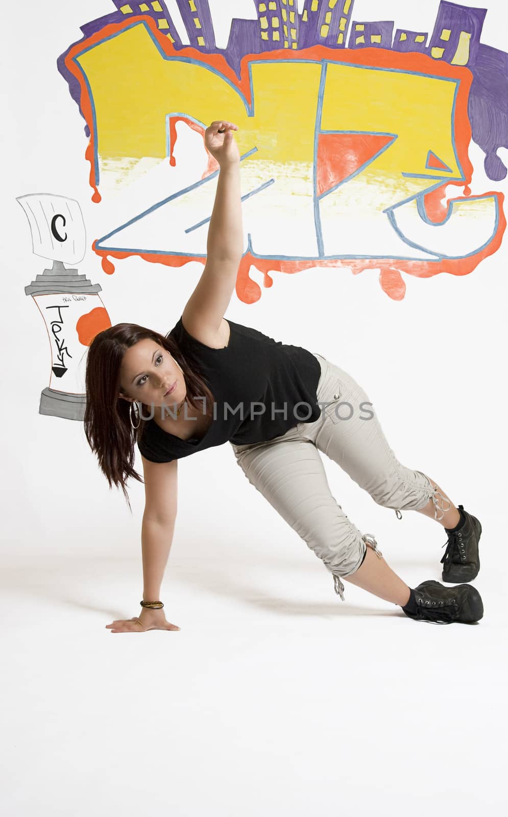 young women in the middle of a breakdancing move balancing on her hand done in front of a graffiti background